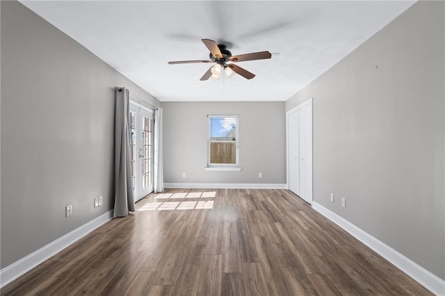 spare room featuring french doors, wood finished floors, a ceiling fan, and baseboards