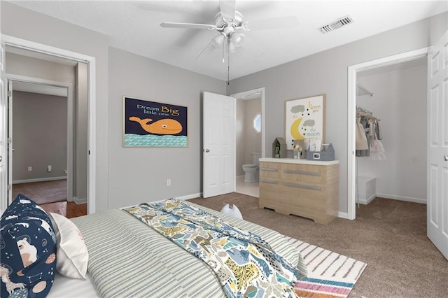 bedroom featuring ensuite bathroom, a ceiling fan, visible vents, baseboards, and carpet