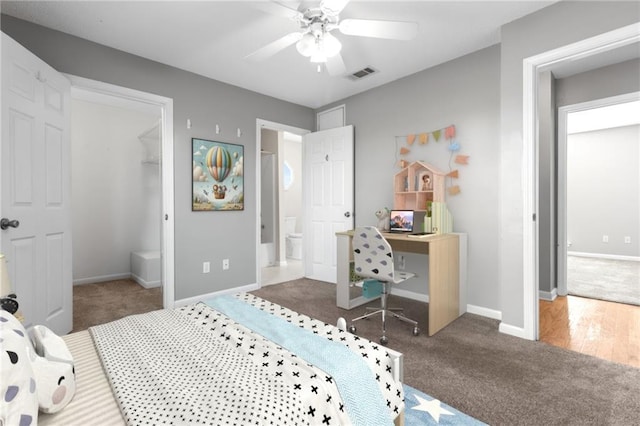 carpeted bedroom featuring a walk in closet, visible vents, ceiling fan, and baseboards