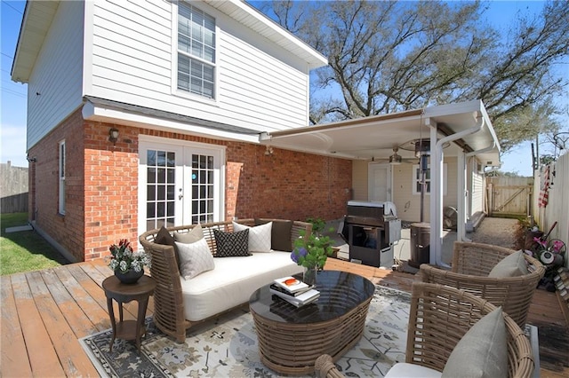 wooden deck with outdoor lounge area, french doors, grilling area, and fence