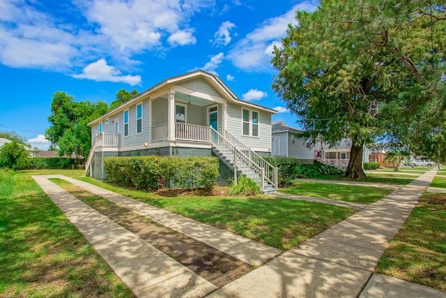 view of front facade featuring a porch, a front lawn, and stairs