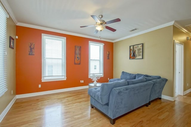 living room featuring visible vents, crown molding, light wood finished floors, and ceiling fan