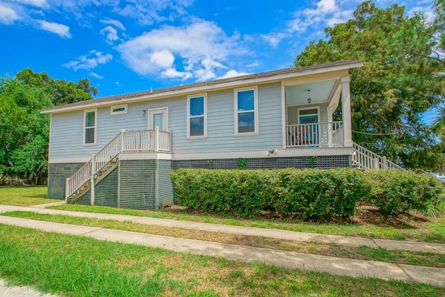 view of front of house with stairs and a front lawn