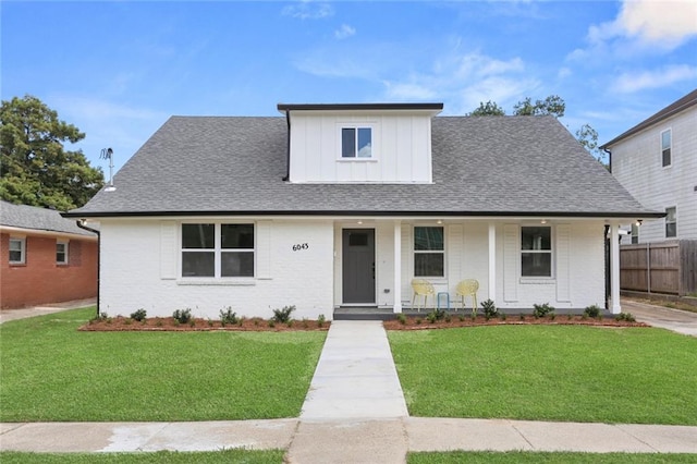 6043 Paris Ave, New Orleans, LA 70122 - view of front of house with board and batten siding, covered porch, brick siding, and a shingled roof