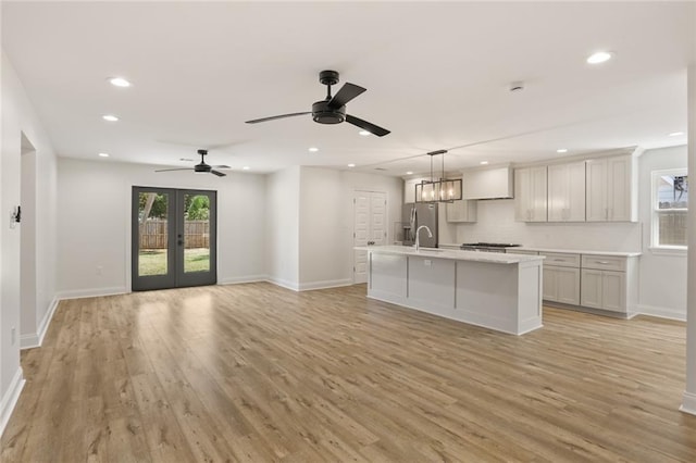 6043 Paris Ave, New Orleans, LA 70122 - unfurnished living room with recessed lighting, light wood-style floors, baseboards, french doors, and a sink