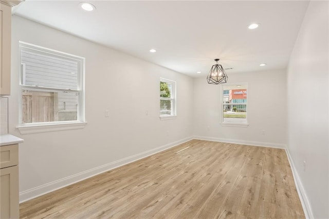 6043 Paris Ave, New Orleans, LA 70122 - empty room with light wood-style flooring, a chandelier, recessed lighting, and baseboards