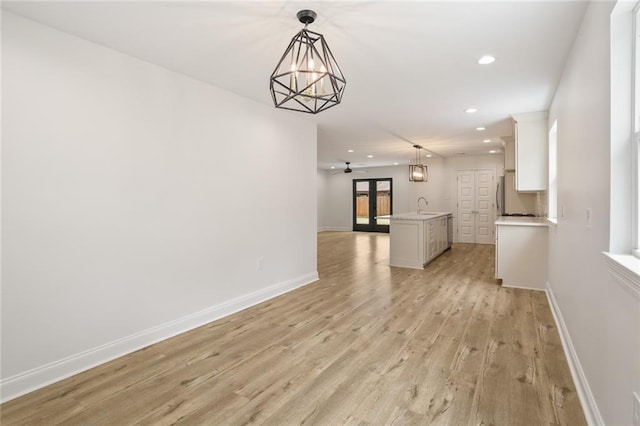 6043 Paris Ave, New Orleans, LA 70122 - unfurnished living room featuring a sink, recessed lighting, light wood-style floors, baseboards, and a chandelier