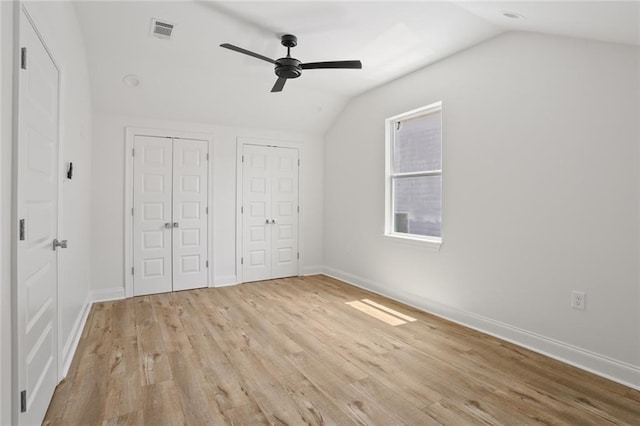 6043 Paris Ave, New Orleans, LA 70122 - unfurnished bedroom with two closets, vaulted ceiling, light wood finished floors, baseboards, and ceiling fan