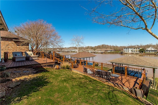 view of dock with a deck with water view and a lawn