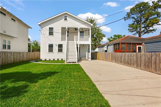 view of front of property with ceiling fan, fence, concrete driveway, and a front yard