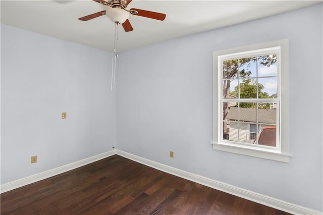 unfurnished room with baseboards, dark wood finished floors, and a ceiling fan