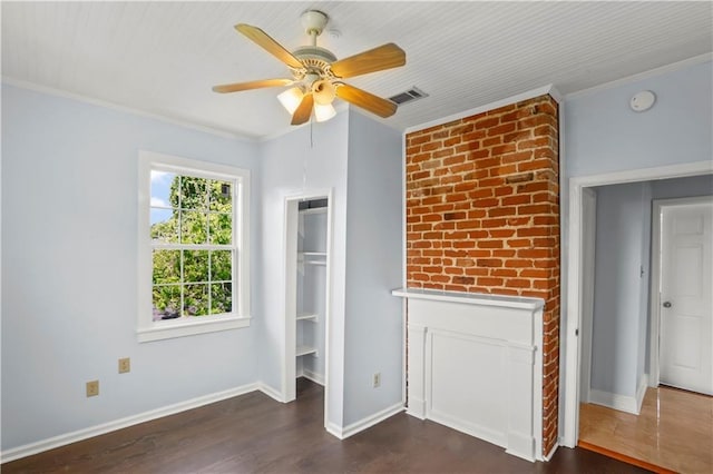 interior space featuring dark wood-style flooring, a ceiling fan, visible vents, baseboards, and ornamental molding