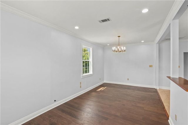 spare room featuring baseboards, visible vents, wood finished floors, and ornamental molding