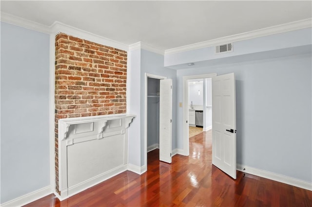 interior space with baseboards, wood finished floors, visible vents, and crown molding