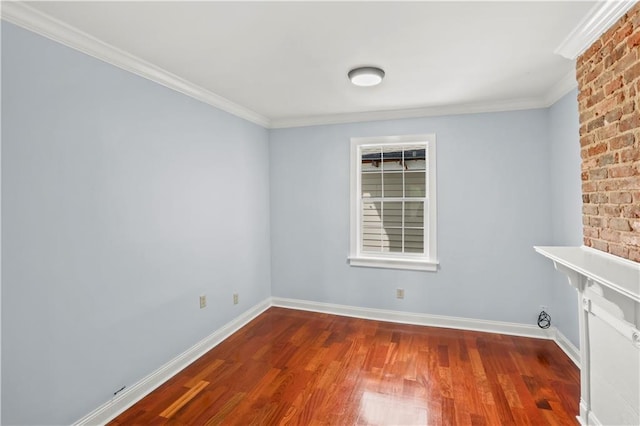 empty room featuring crown molding, baseboards, and wood finished floors