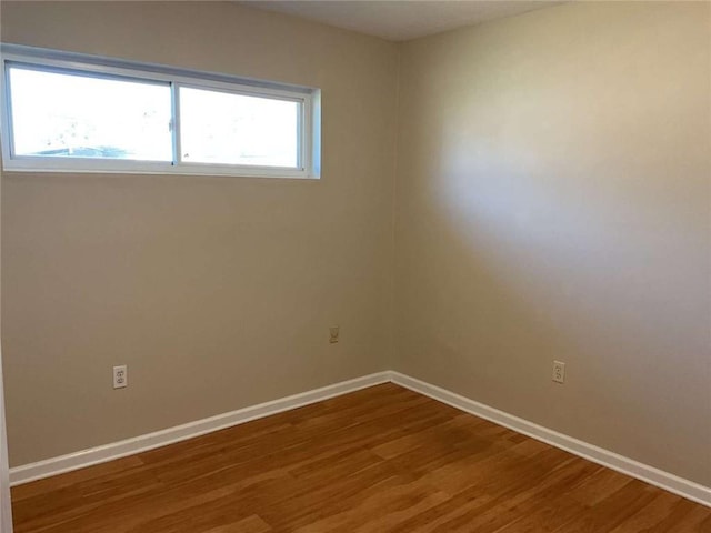 unfurnished room featuring baseboards and wood finished floors