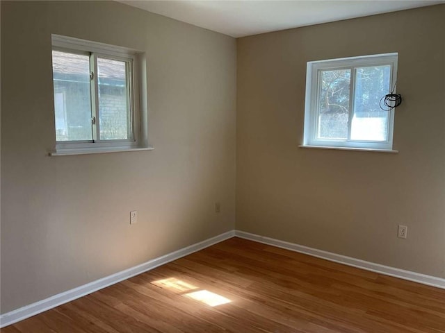 empty room featuring baseboards and wood finished floors