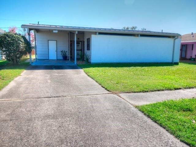 view of front facade featuring driveway and a front yard