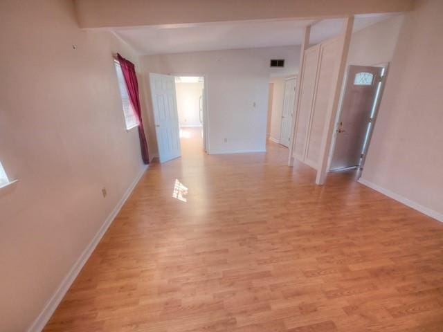 spare room featuring baseboards, visible vents, and light wood finished floors