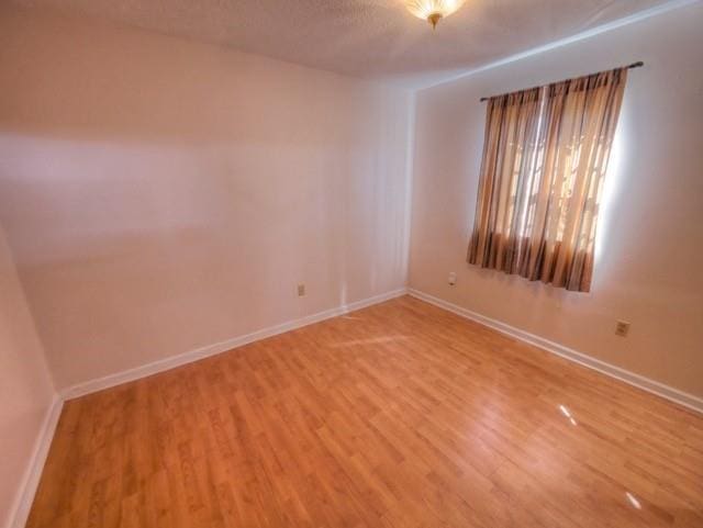 empty room featuring light wood-style floors and baseboards