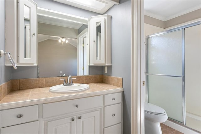 bathroom with ornamental molding, a stall shower, vanity, and toilet