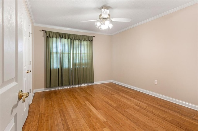 spare room featuring ornamental molding, baseboards, ceiling fan, and light wood finished floors