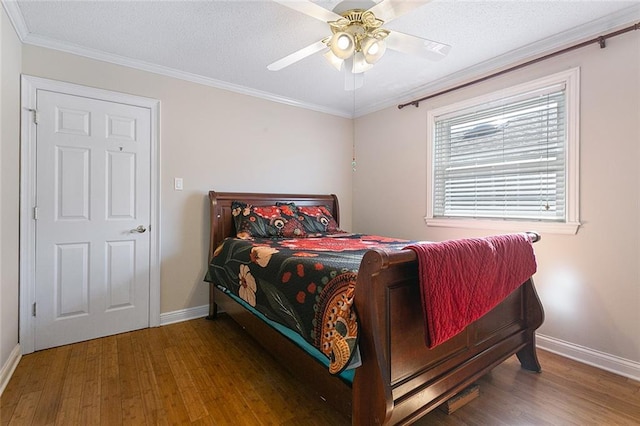 bedroom featuring crown molding, baseboards, and wood finished floors