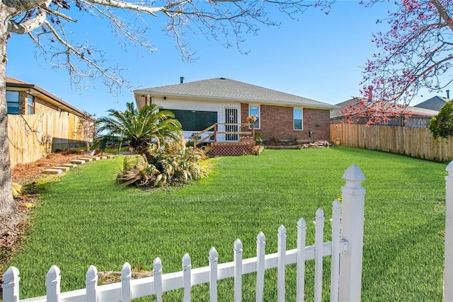 exterior space featuring fence private yard, a lawn, and brick siding