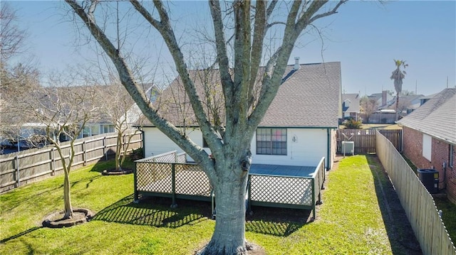 rear view of property with a deck, a yard, central AC, and a fenced backyard