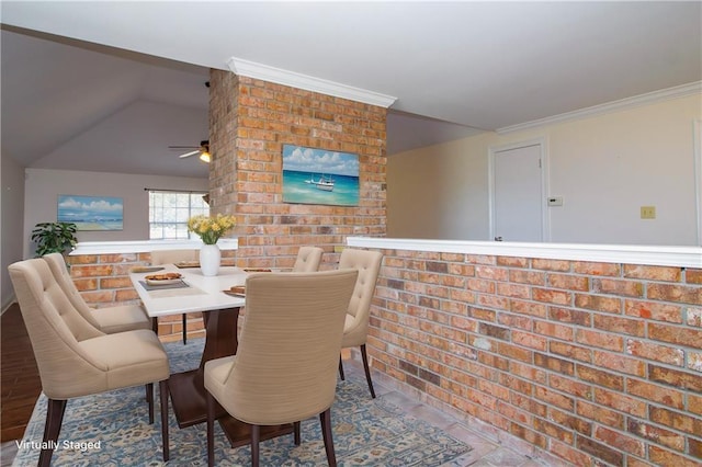 dining area with ornamental molding, vaulted ceiling, and brick wall