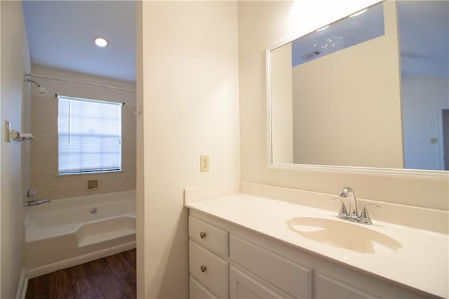 full bathroom with a tub, wood finished floors, and vanity