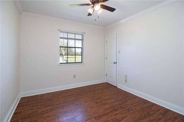 spare room with crown molding, dark wood finished floors, and baseboards