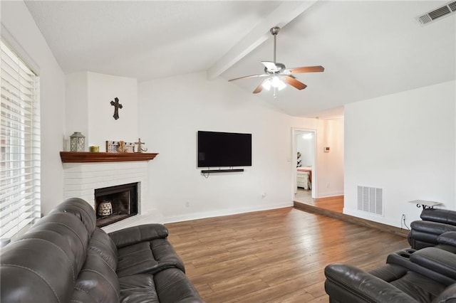38 Moss Dr, La Place, LA 70068 - living room featuring vaulted ceiling with beams, a brick fireplace, wood finished floors, and visible vents