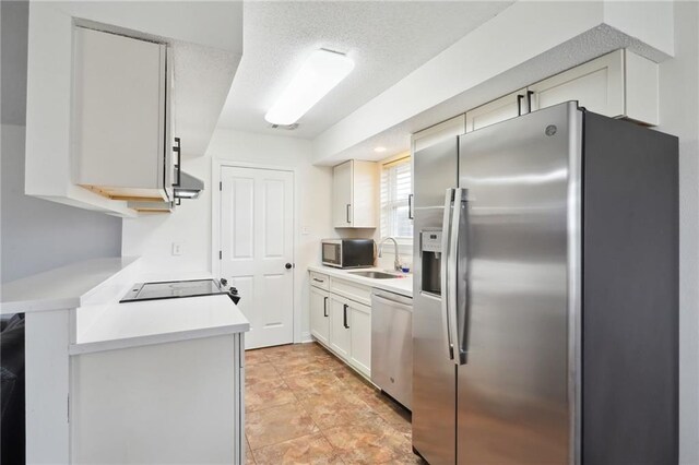 38 Moss Dr, La Place, LA 70068 - kitchen featuring light countertops, appliances with stainless steel finishes, white cabinetry, a sink, and a textured ceiling