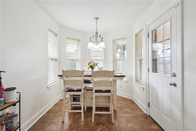 38 Moss Dr, La Place, LA 70068 - dining area featuring a textured ceiling, a chandelier, and baseboards