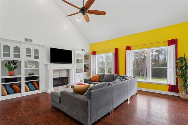 living room with wood-type flooring, a fireplace, visible vents, and a ceiling fan