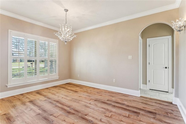 empty room featuring arched walkways, baseboards, crown molding, and light wood finished floors