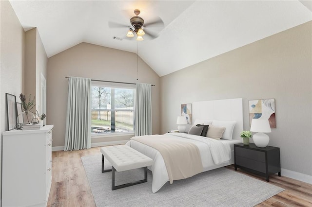 bedroom featuring visible vents, baseboards, a ceiling fan, lofted ceiling, and light wood-style floors