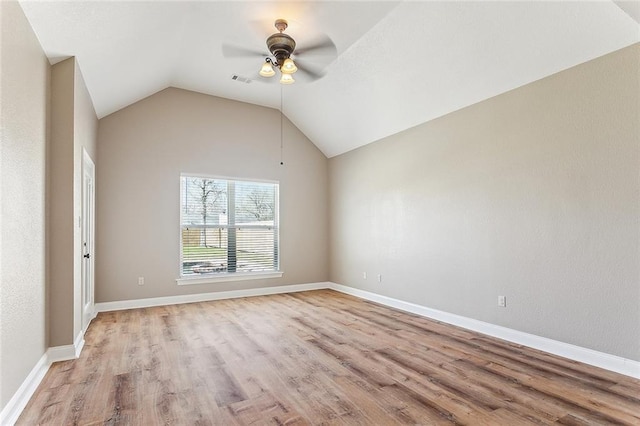 unfurnished room with ceiling fan, light wood-style flooring, visible vents, baseboards, and vaulted ceiling