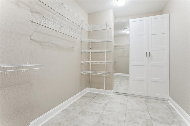 spacious closet with light tile patterned floors