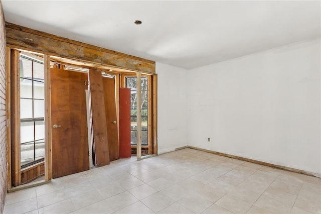 unfurnished room featuring a healthy amount of sunlight and baseboards