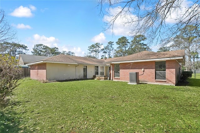 back of house featuring central air condition unit, a yard, fence, and brick siding