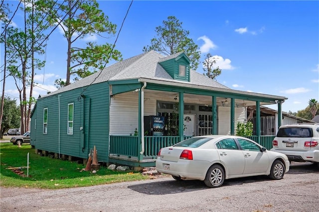 view of front of home with a porch and roof with shingles