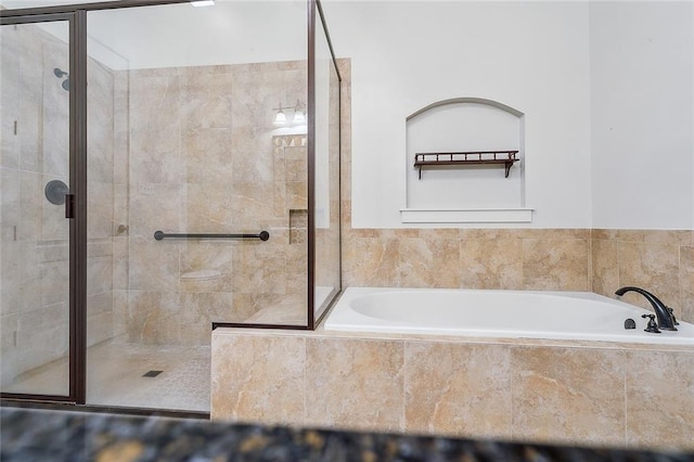 bathroom featuring a stall shower and a bath