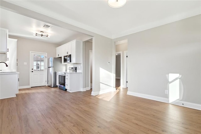 unfurnished living room with light wood-style floors, visible vents, and baseboards