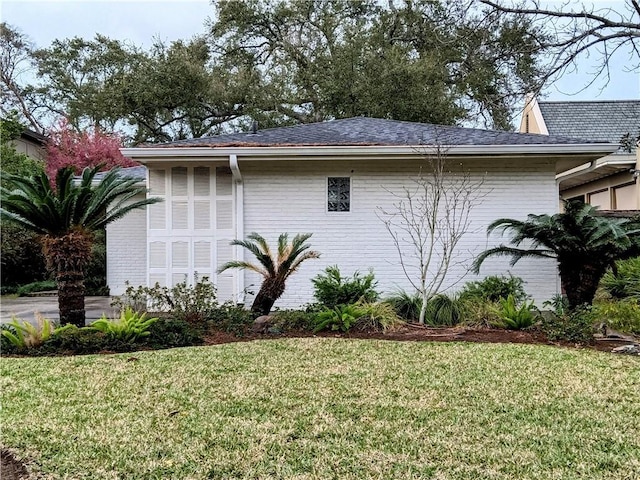 view of property exterior featuring brick siding and a lawn