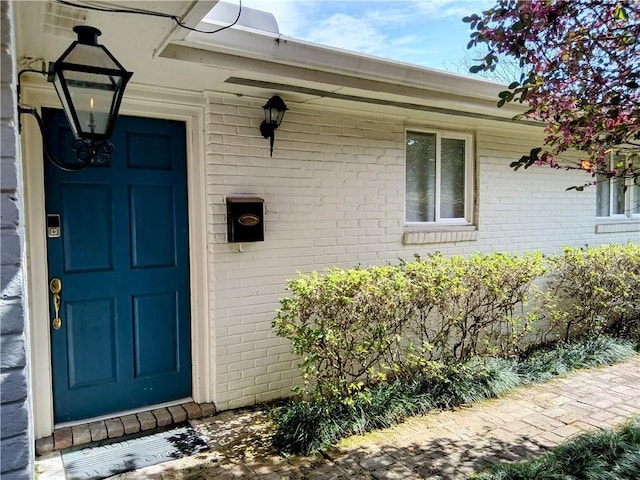 doorway to property featuring brick siding