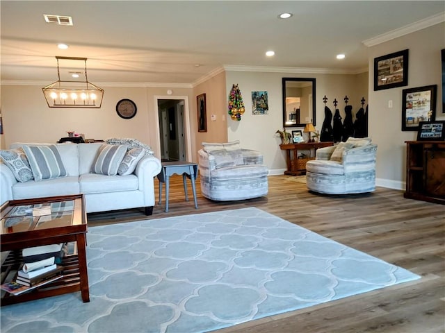 living area with ornamental molding, recessed lighting, visible vents, and wood finished floors