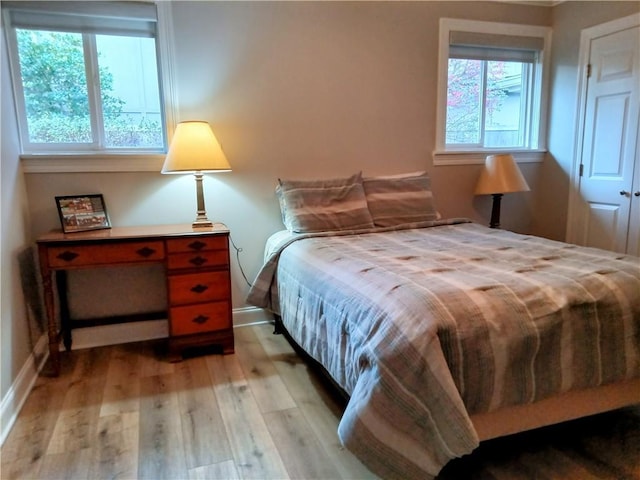 bedroom featuring light wood-type flooring and baseboards