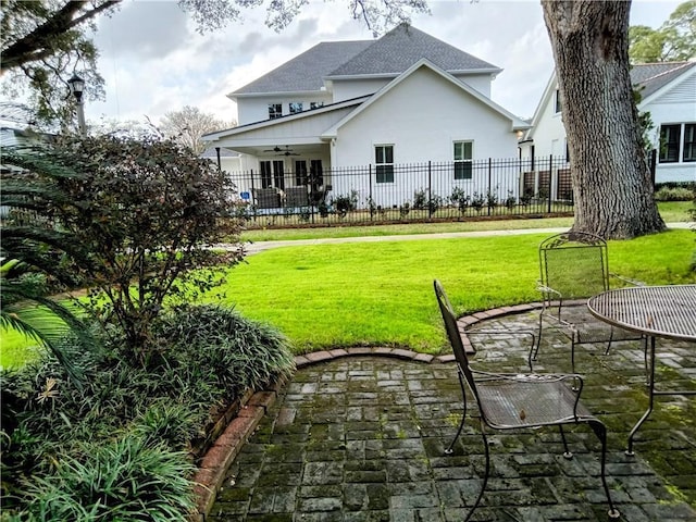 back of house with a ceiling fan, a lawn, fence, a patio area, and stucco siding